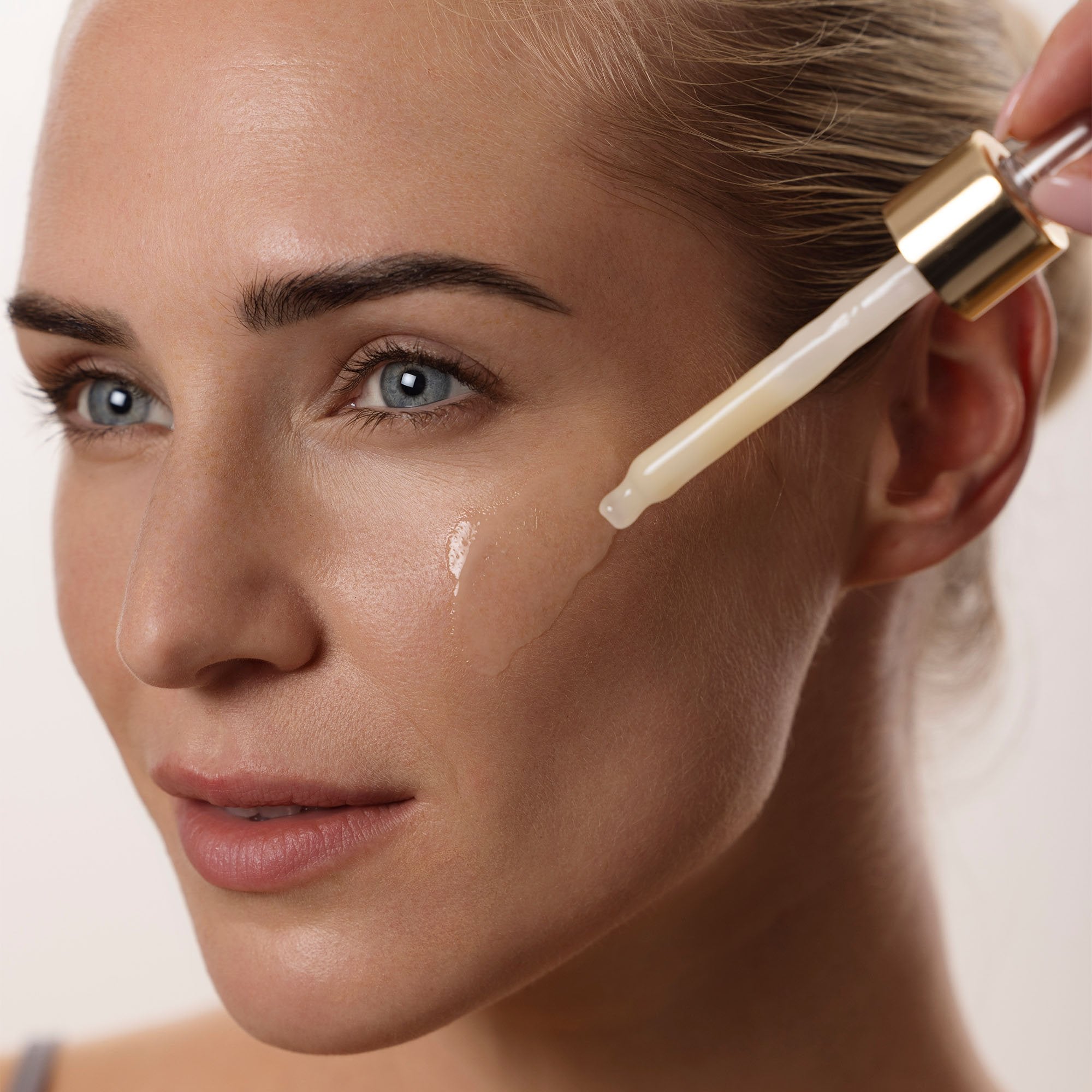 Application du sérum visage Équilibre Idéal sur le visage par une femme, soin pour peaux mixtes