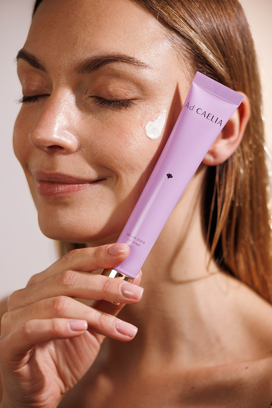 Application de la crème solaire visage Ad CAELIA pour une protection UV haute performance ve un teint éclatant