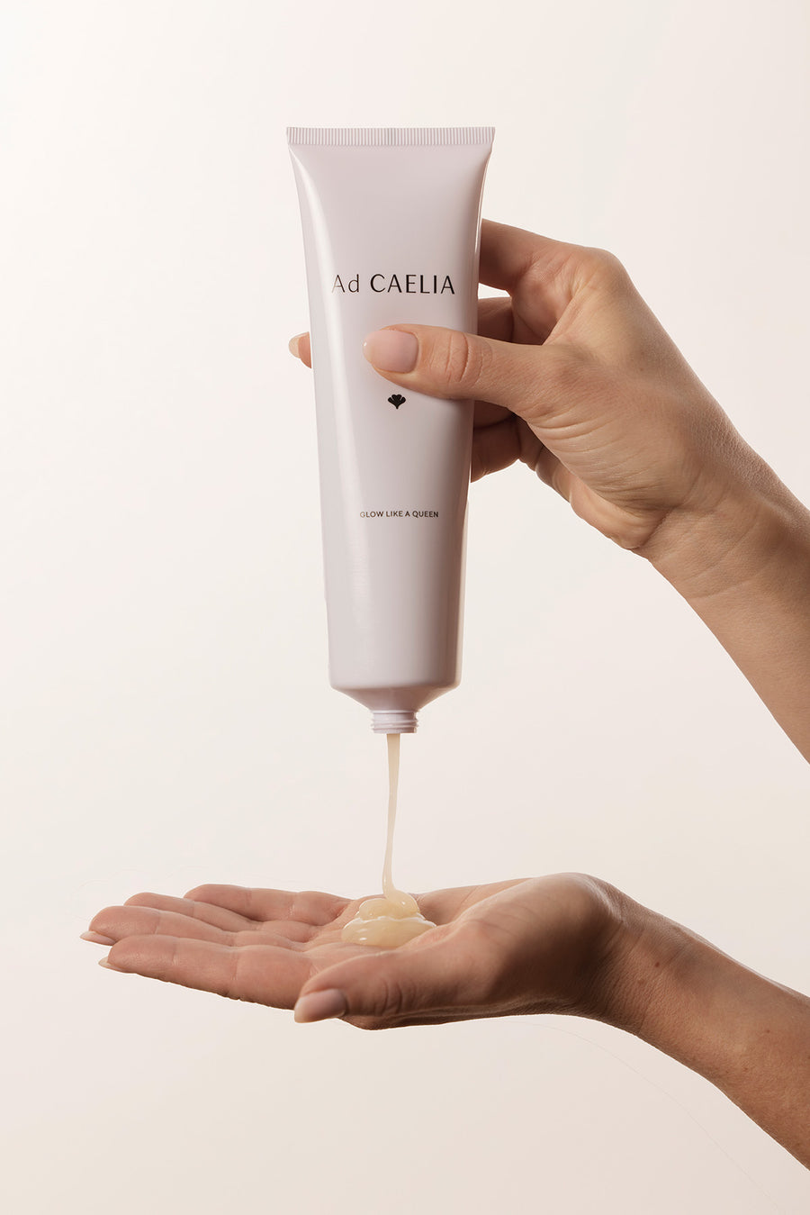 Gel nettoyant fluide et ambré s'écoulant d'un tube cosmétique blanc dans une main ouverte pour le rituel Ad CAELIA